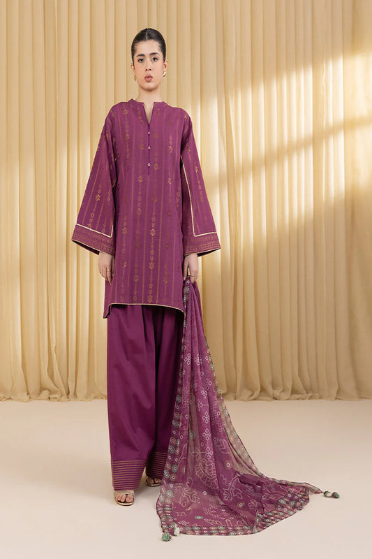 Woman wearing a traditional purple outfit with a matching dupatta against a beige curtain background