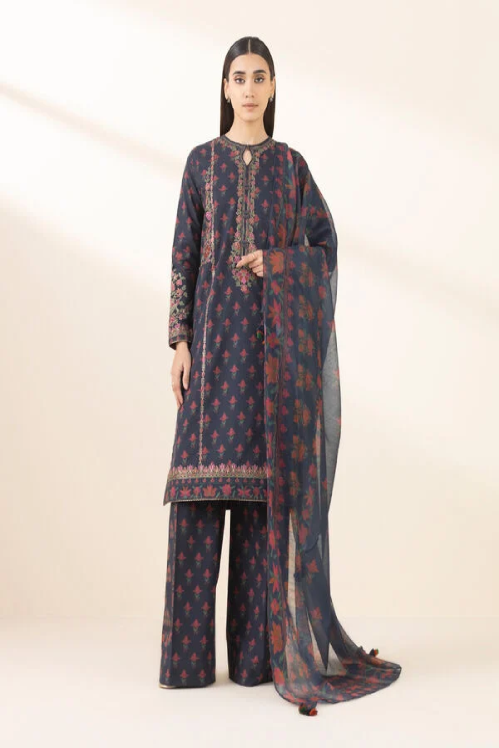 Woman wearing a traditional outfit with a dark blue and red pattern on a white background