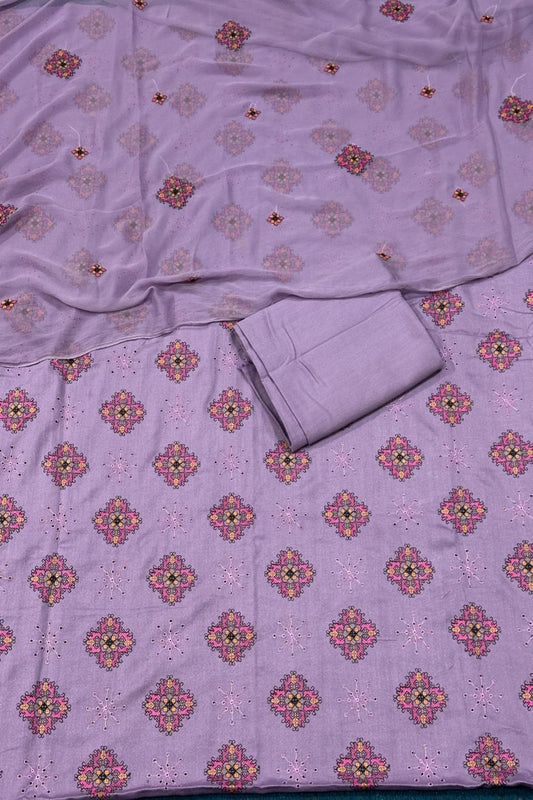 Purple fabric with floral patterns, including a folded piece of fabric on top.