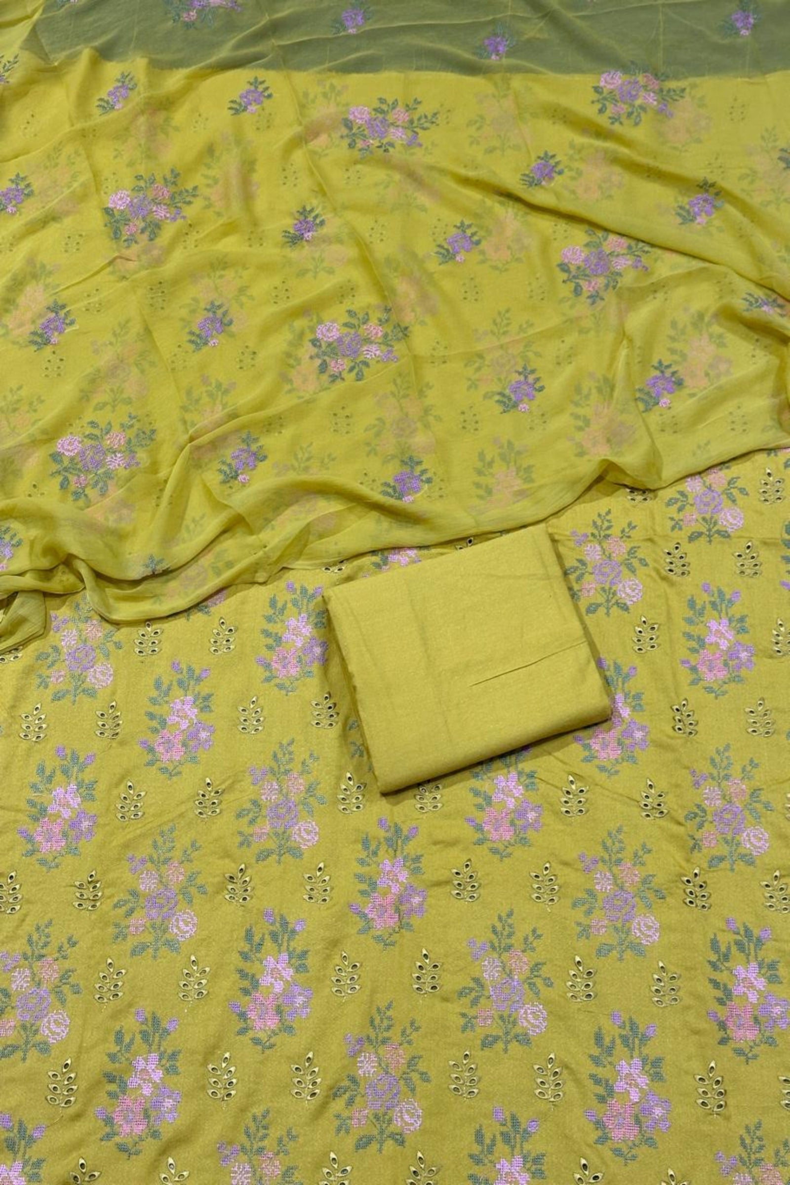 Green fabric with floral pattern and a folded green fabric piece on top