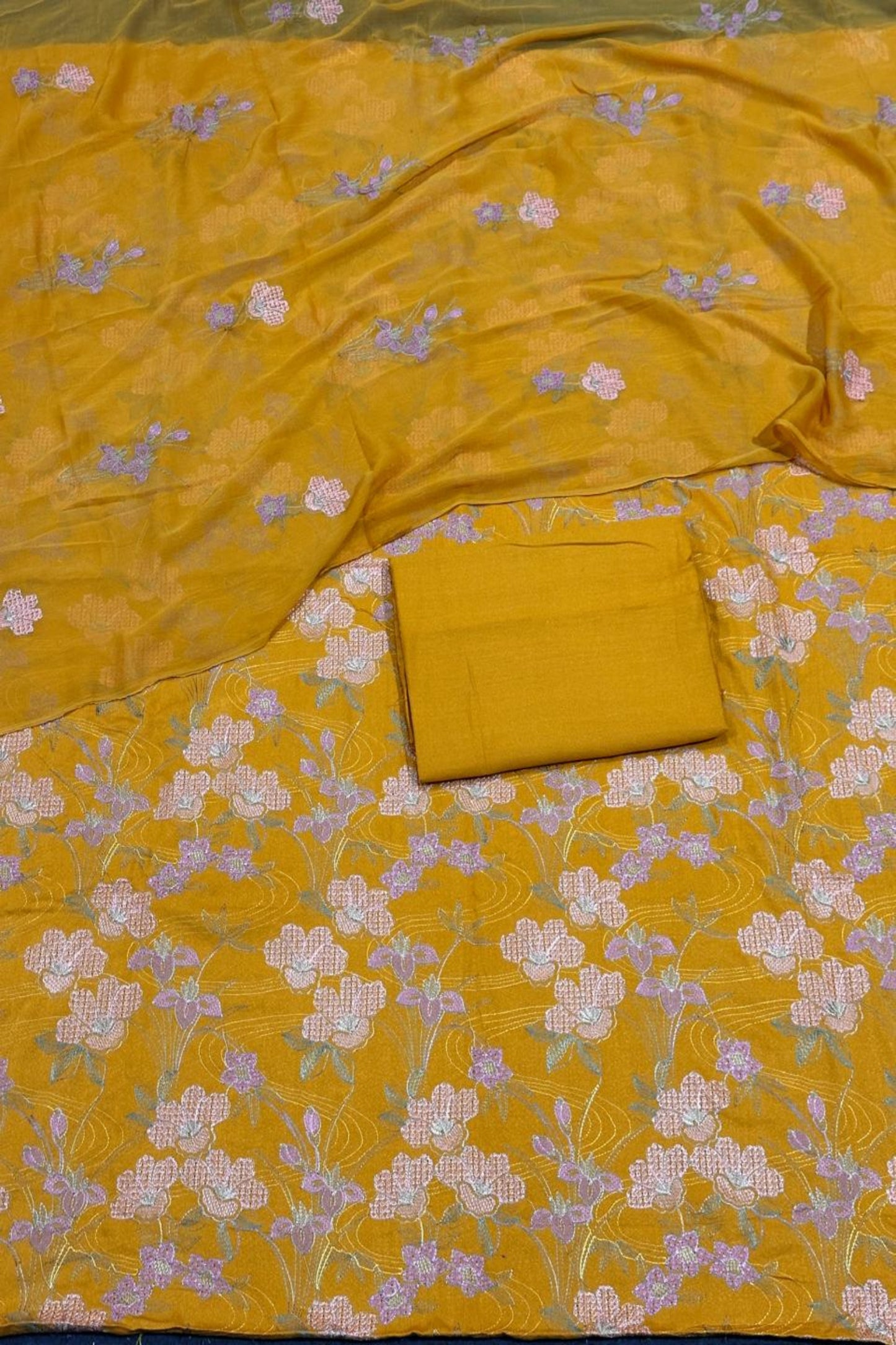 Yellow fabric with floral pattern and a folded yellow fabric piece on top