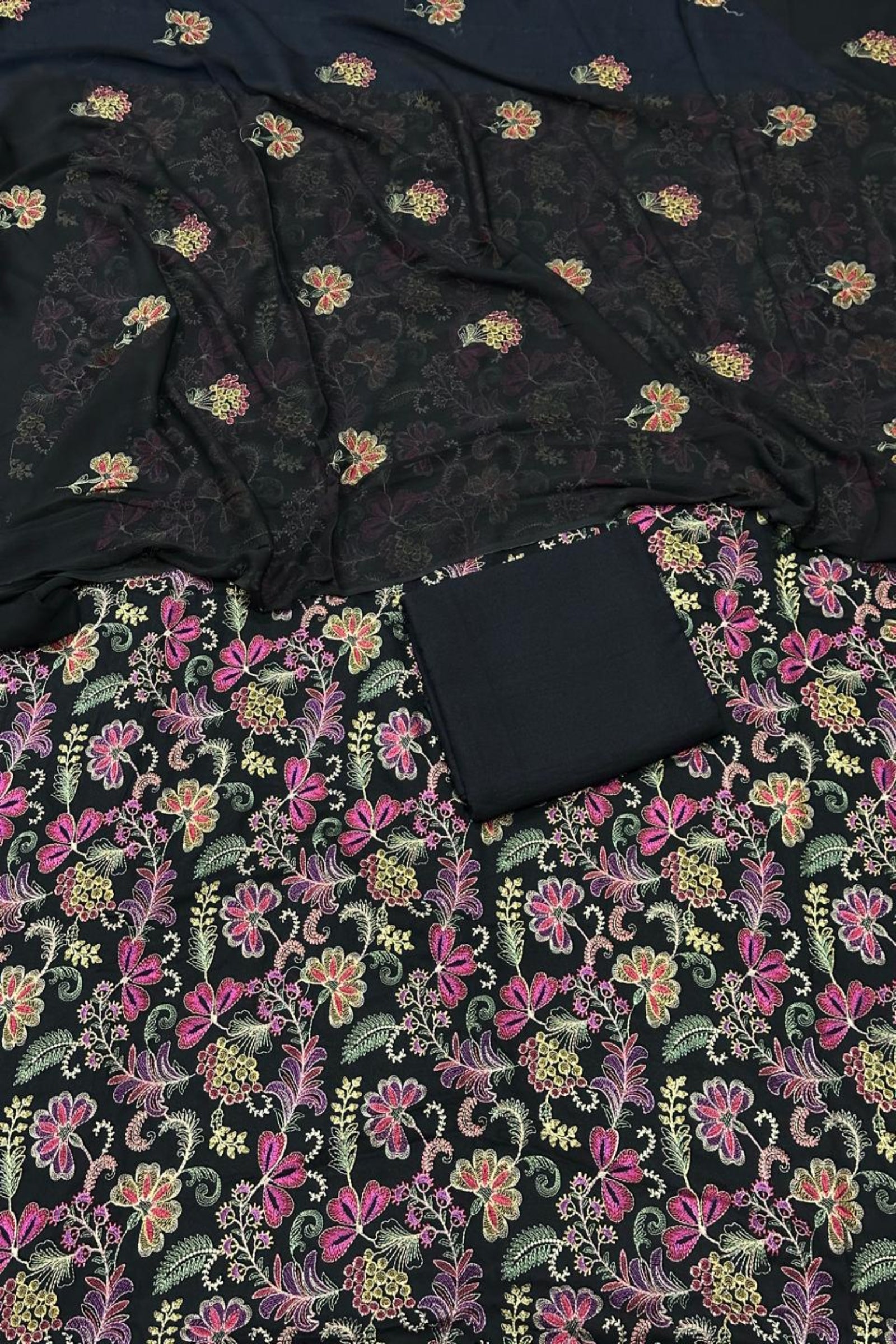 Black fabric with colorful floral patterns on a black background