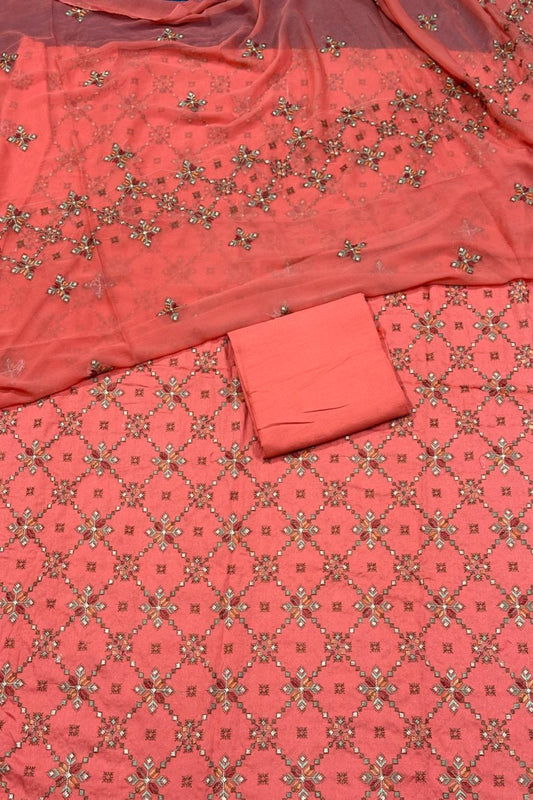 Coral fabric with intricate gold patterns on a matching background