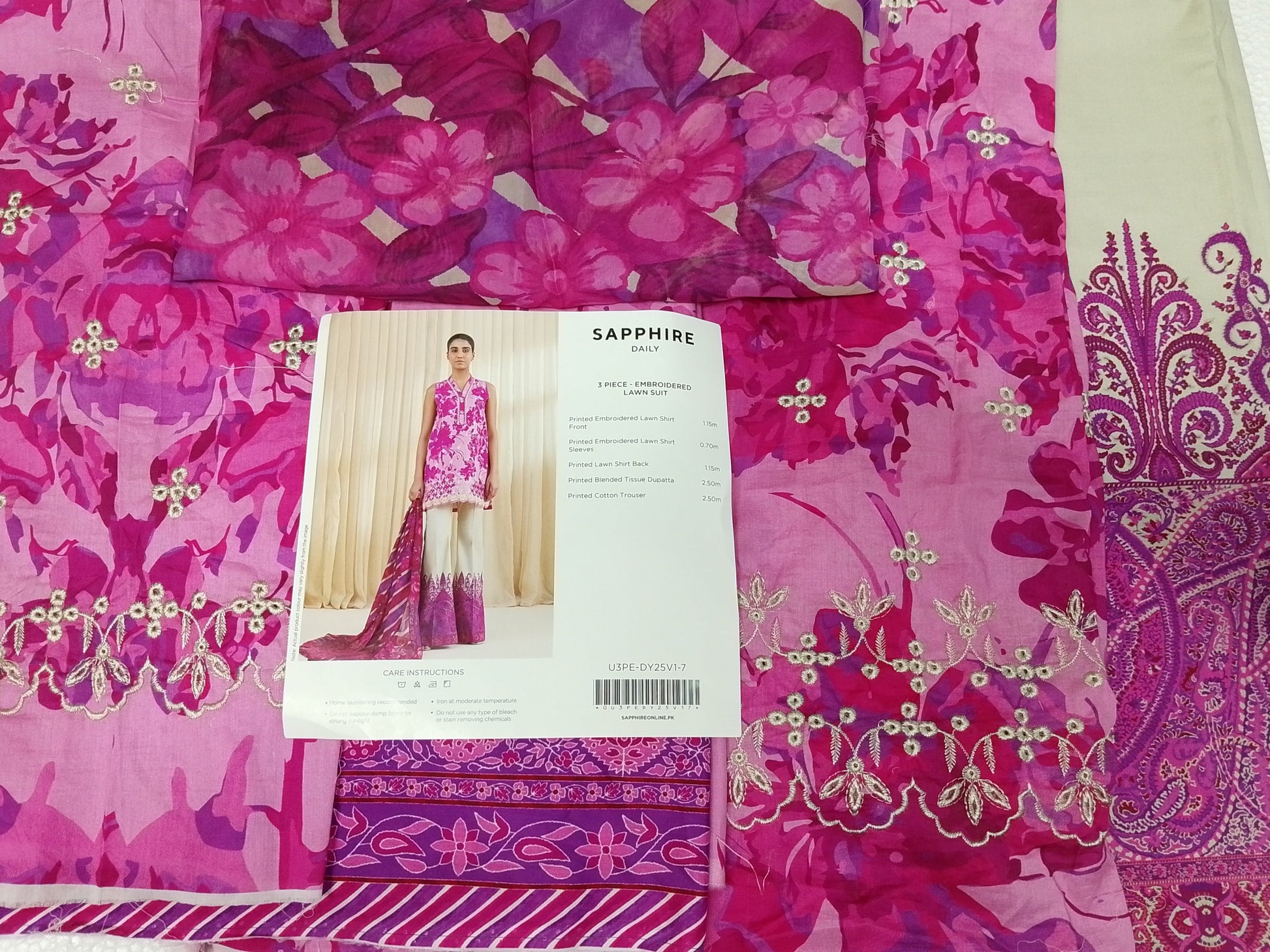 Pink and purple patterned fabric with a garment tag showing a model wearing a similar outfit.