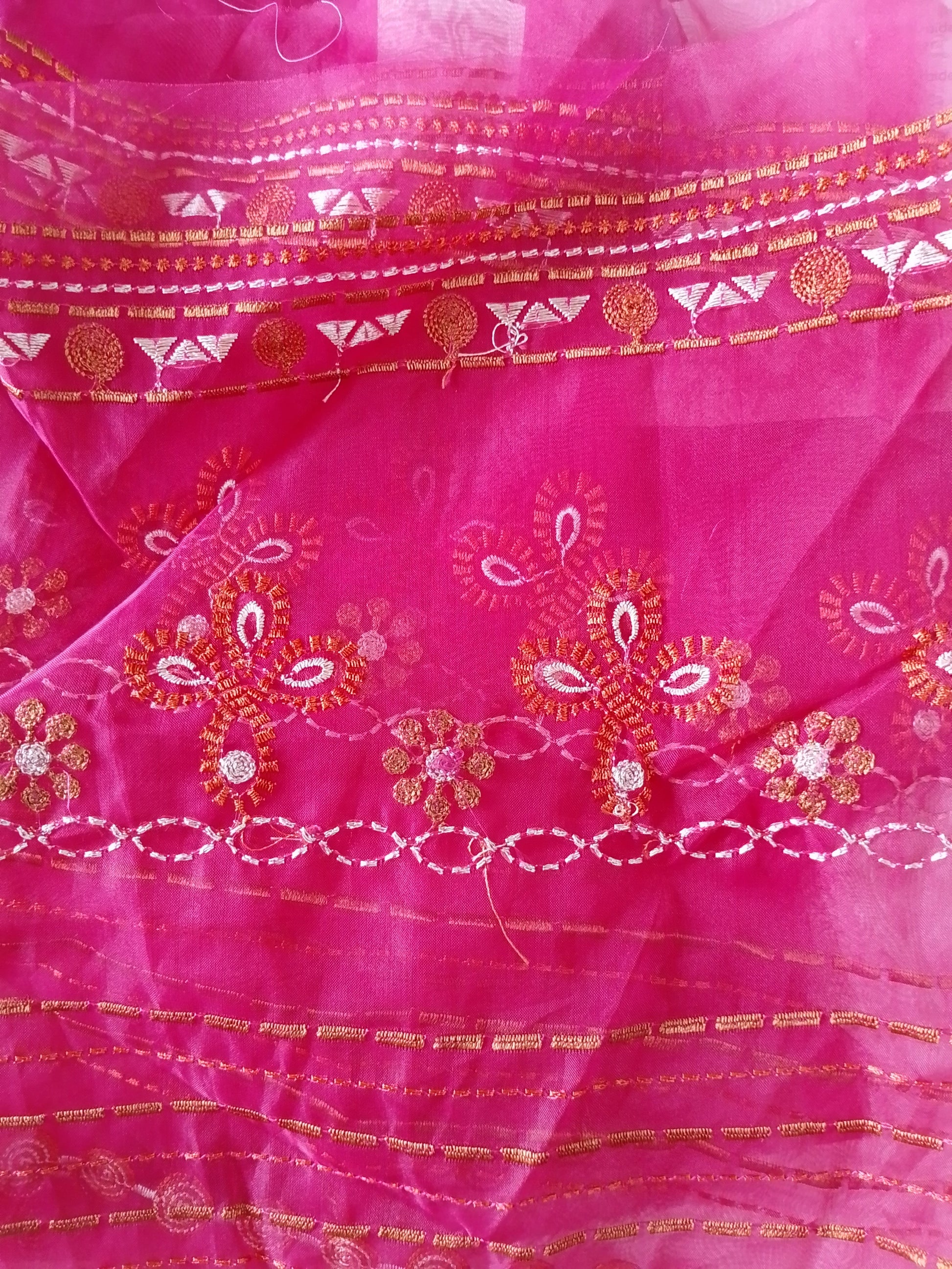 Pink fabric with intricate gold and red embroidery