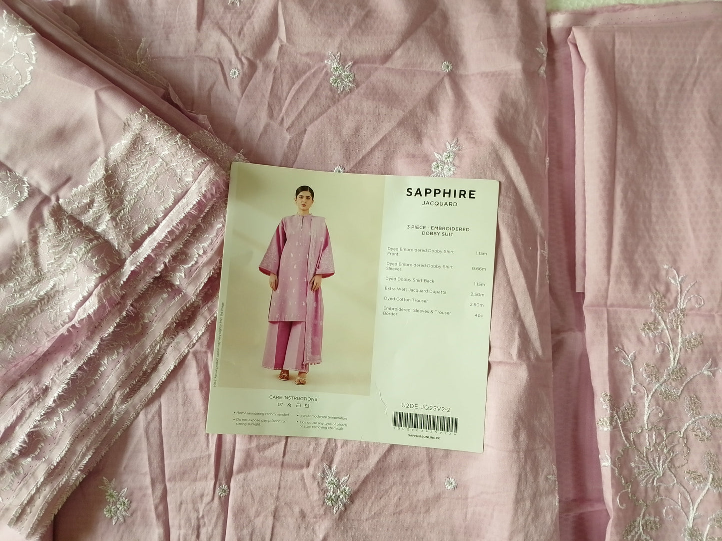 Pink fabric with a pattern and a card on top