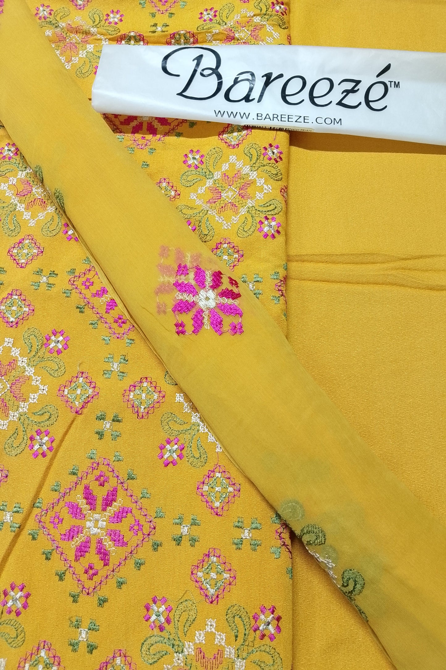 Yellow fabric with floral embroidery and Bareeze branding