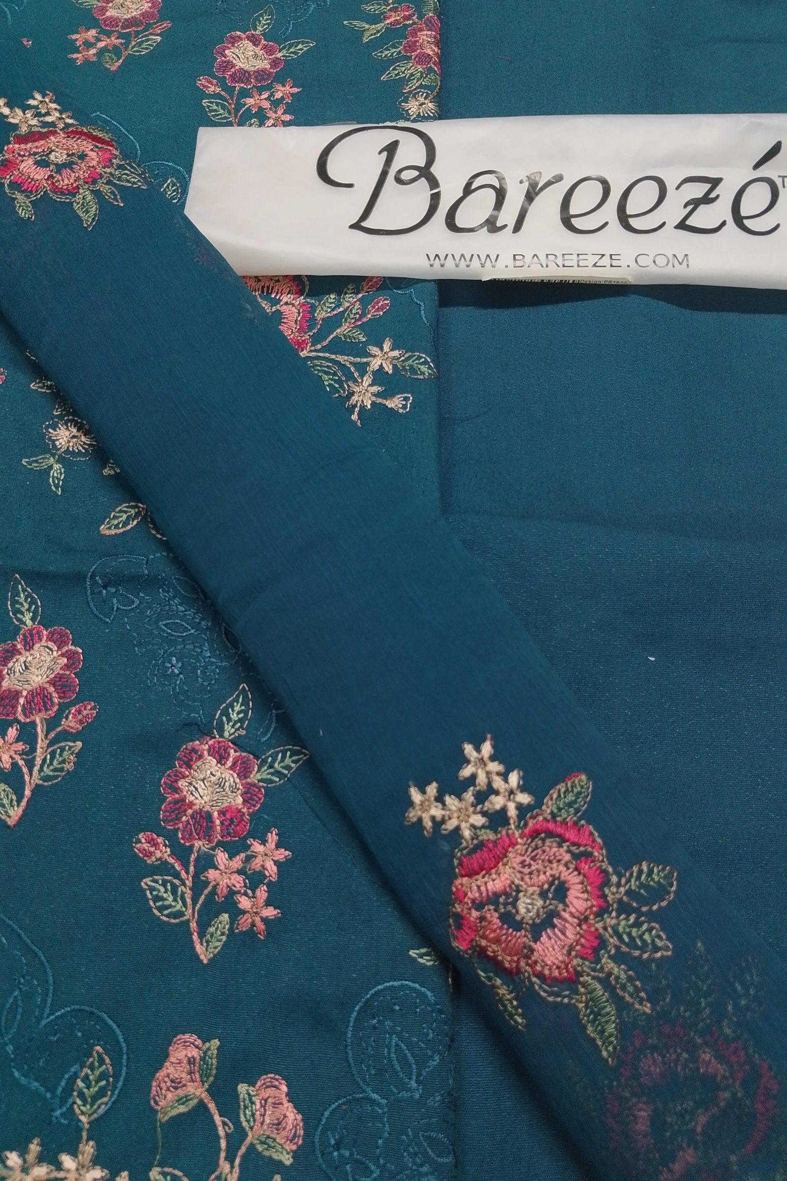 Teal fabric with floral embroidery and Bareezé label