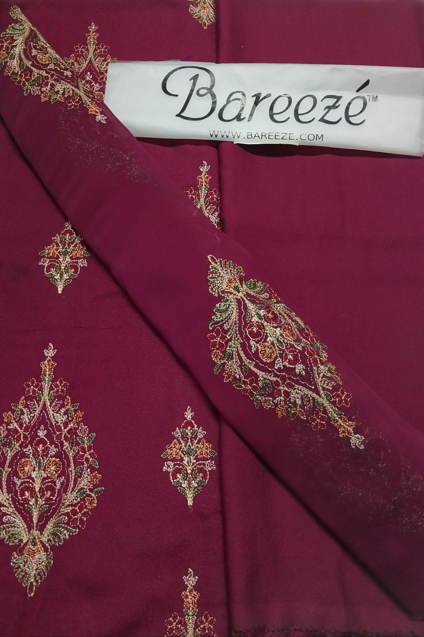 Maroon fabric with intricate gold embroidery and Bareezé label.