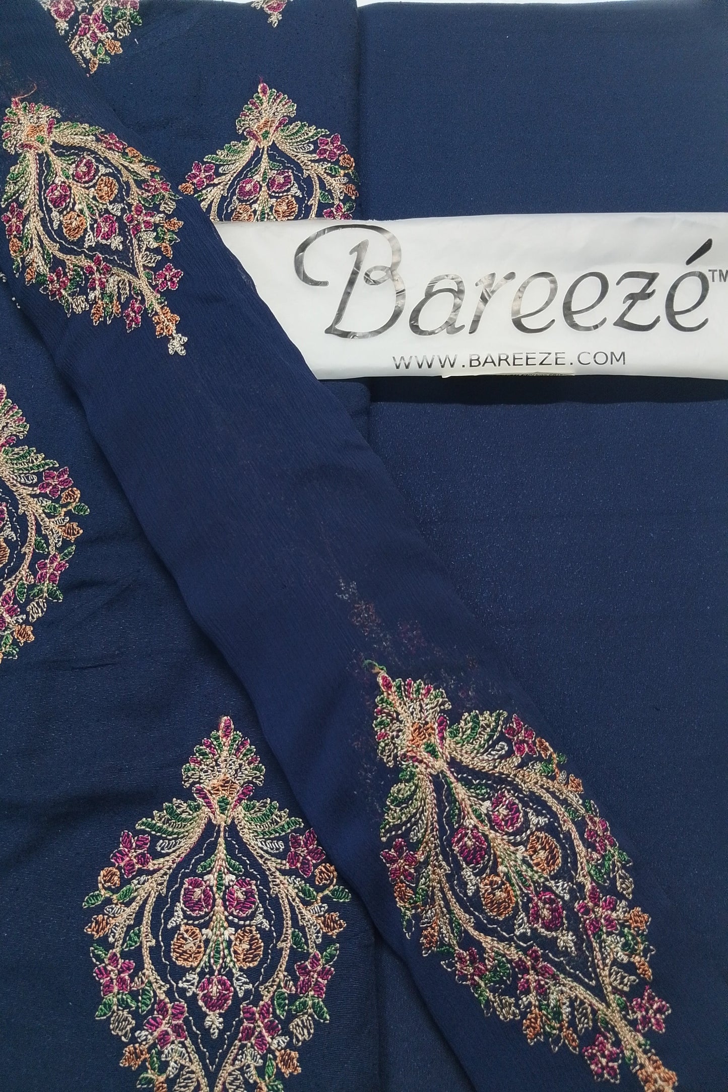 Navy blue fabric with intricate multicolored embroidery and Bareeze label.