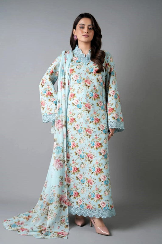 Woman wearing a floral dress with a matching dupatta against a gray background