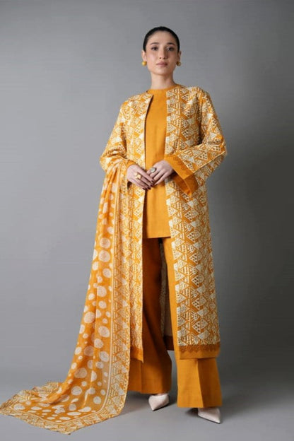 Woman wearing a mustard yellow traditional outfit with a patterned shawl on a gray background