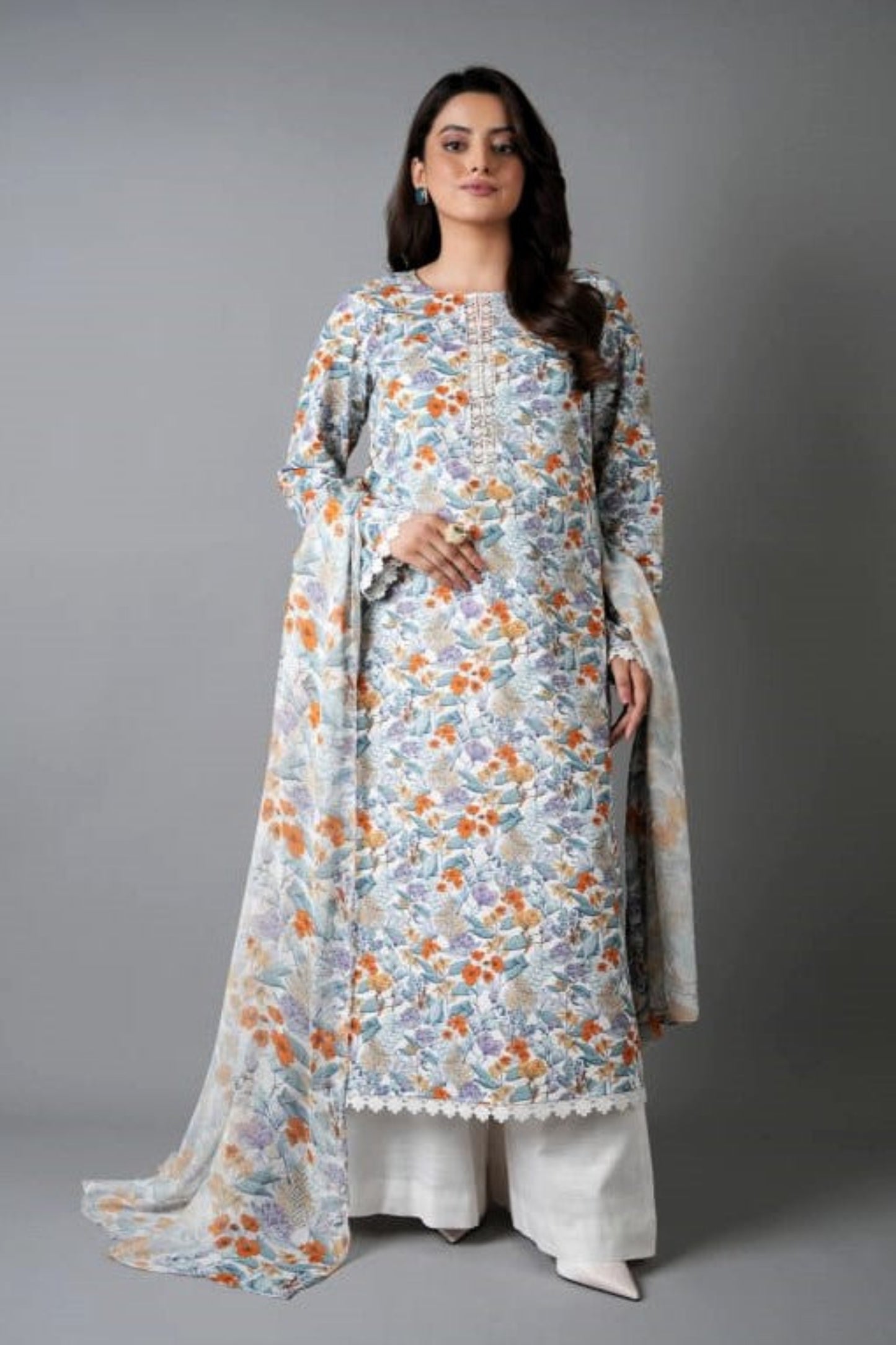 Woman wearing a floral dress with a plain drape against a gray background