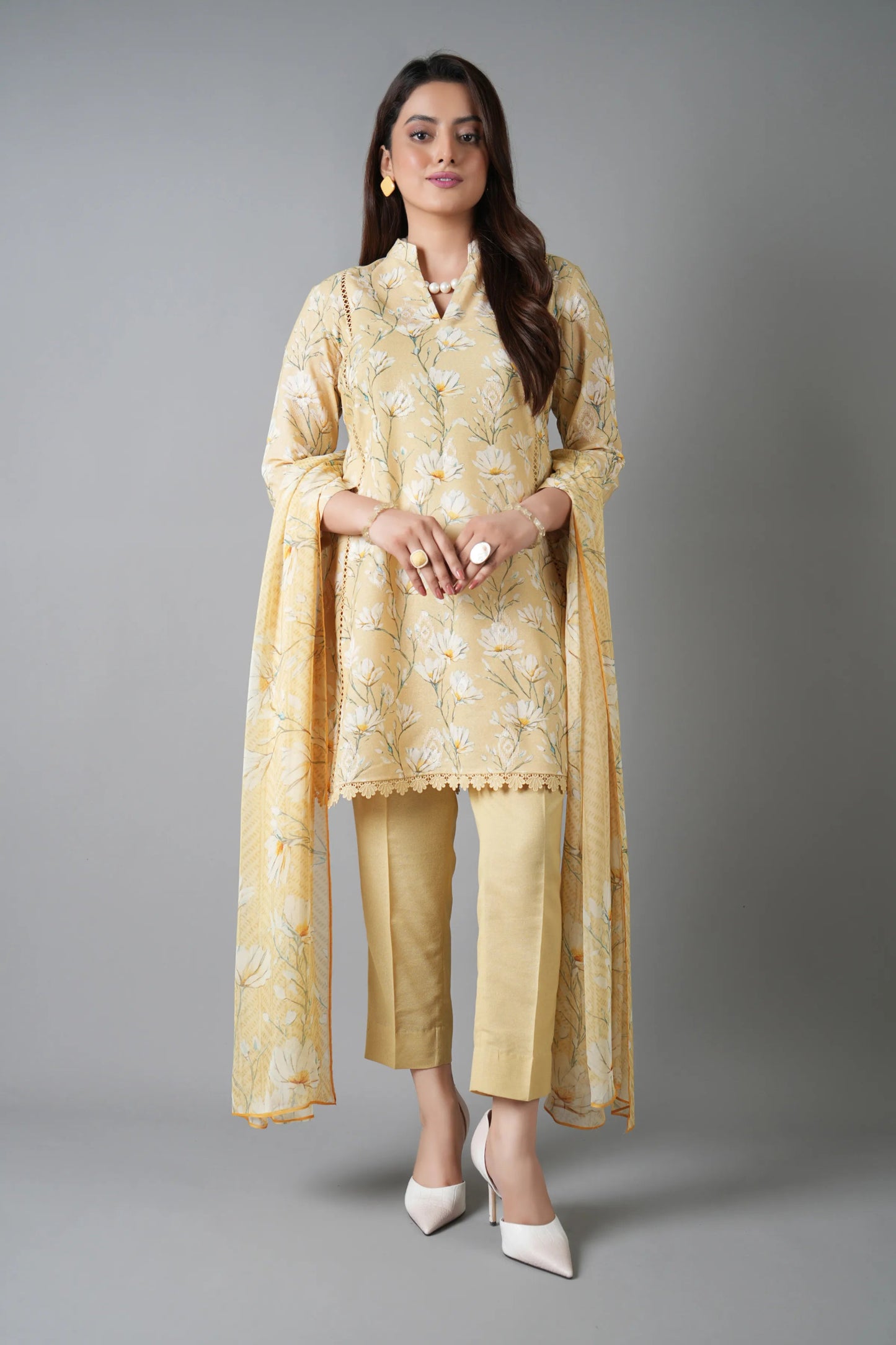 Woman wearing a yellow traditional outfit with a plain background