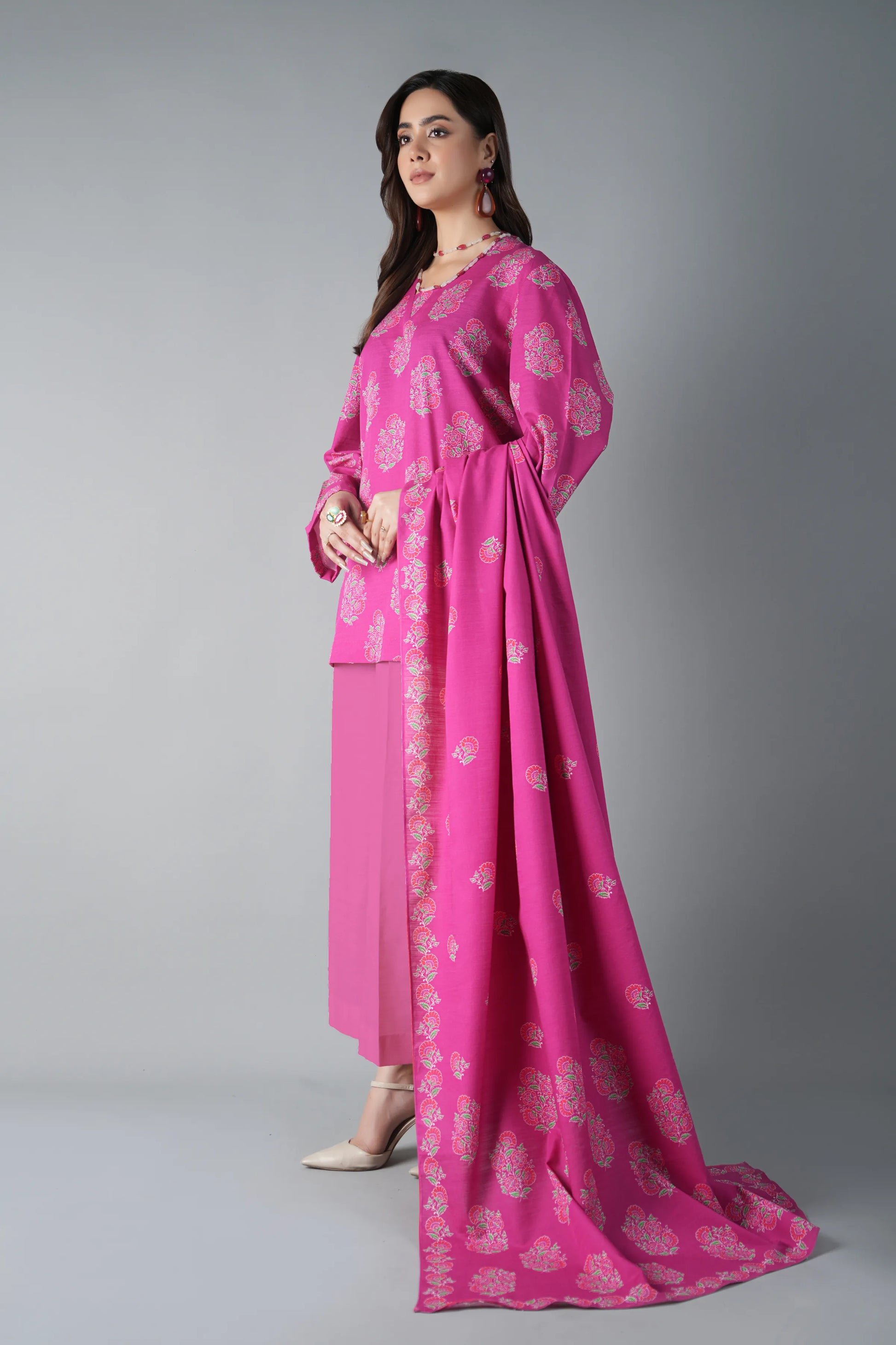 Woman wearing a pink traditional outfit with a gray background