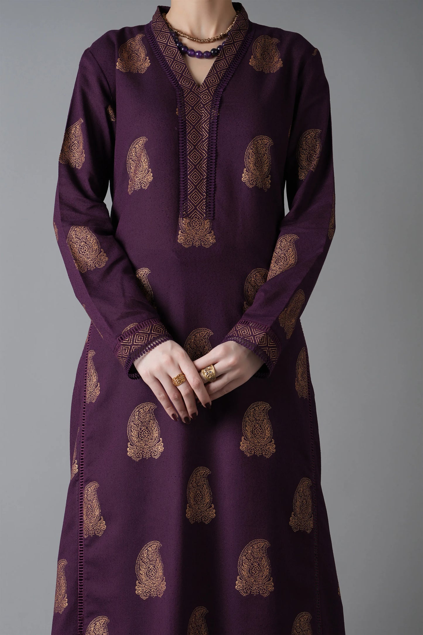 Purple dress with gold patterns on a gray background
