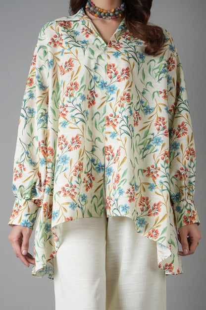 Woman wearing a floral blouse with long sleeves on a gray background