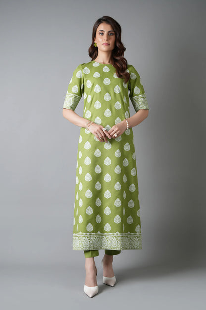 Woman wearing a green and white patterned outfit on a gray background